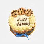 White round cake with creamy swirls and three paw-shaped cookie toppers.