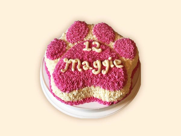aw cake with pink frosting and custom message written in cream for dog
