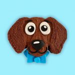 Cute dachshund-themed dog birthday cake comes with a large fondant face with long ears and a blue bow.