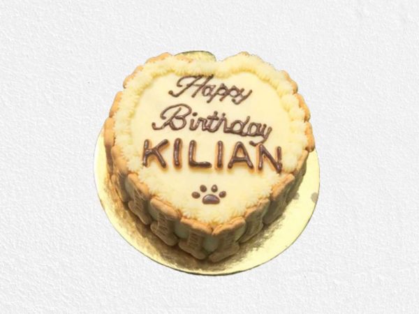 A beige cake with piped cream and biscuit border