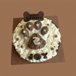 Round cake with textured frosting shaped like a paw print in the center
