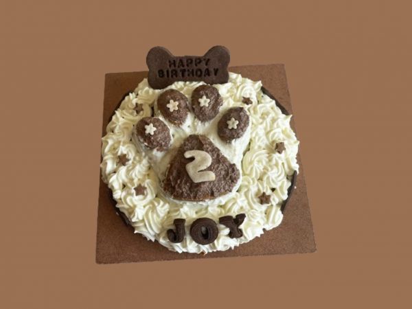 Round cake with textured frosting shaped like a paw print in the center