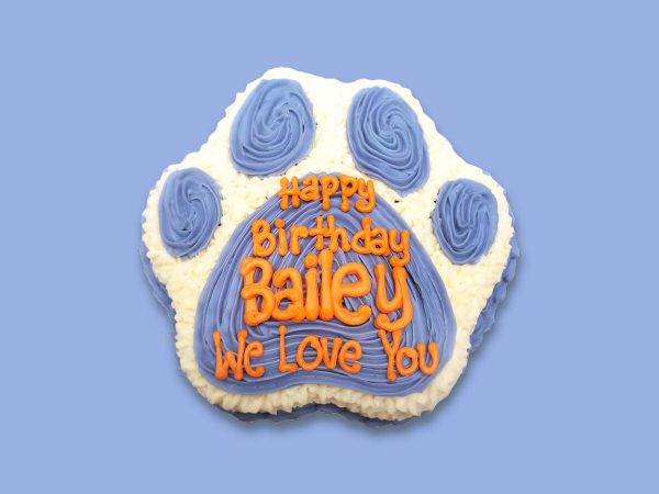 Blue and white paw birthday cake in paw shape with custom text on top