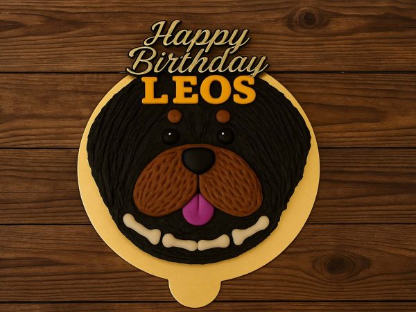 Rottweiler-themed dog face cake with black and brown icing and Happy Birthday topper.