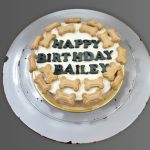 Round dog birthday cake topped with mini bone-shaped treats