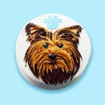 Yorkshire face dog cake with realistic brown and black and blue paw print topper.