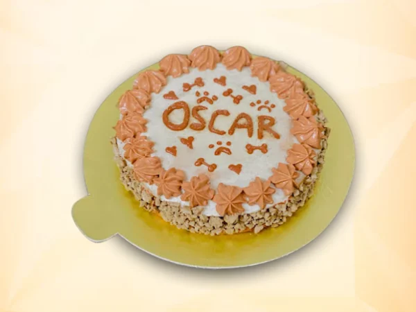 Round dog cake with white frosting, peach cream border, and cute designs