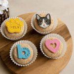 Cat-themed cupcakes with paw, cat face, heart, and milestone toppers