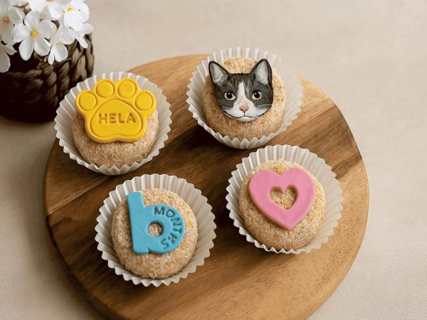 Cat-themed cupcakes with paw, cat face, heart, and milestone toppers