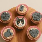 Cat-themed birthday cupcakes with paw, cat face, and love toppers
